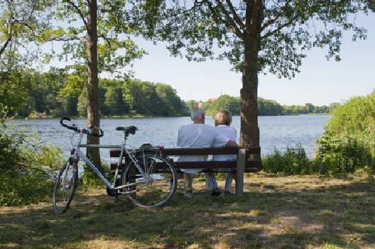 Paar mit Fahrrädern sitzt am Wasser